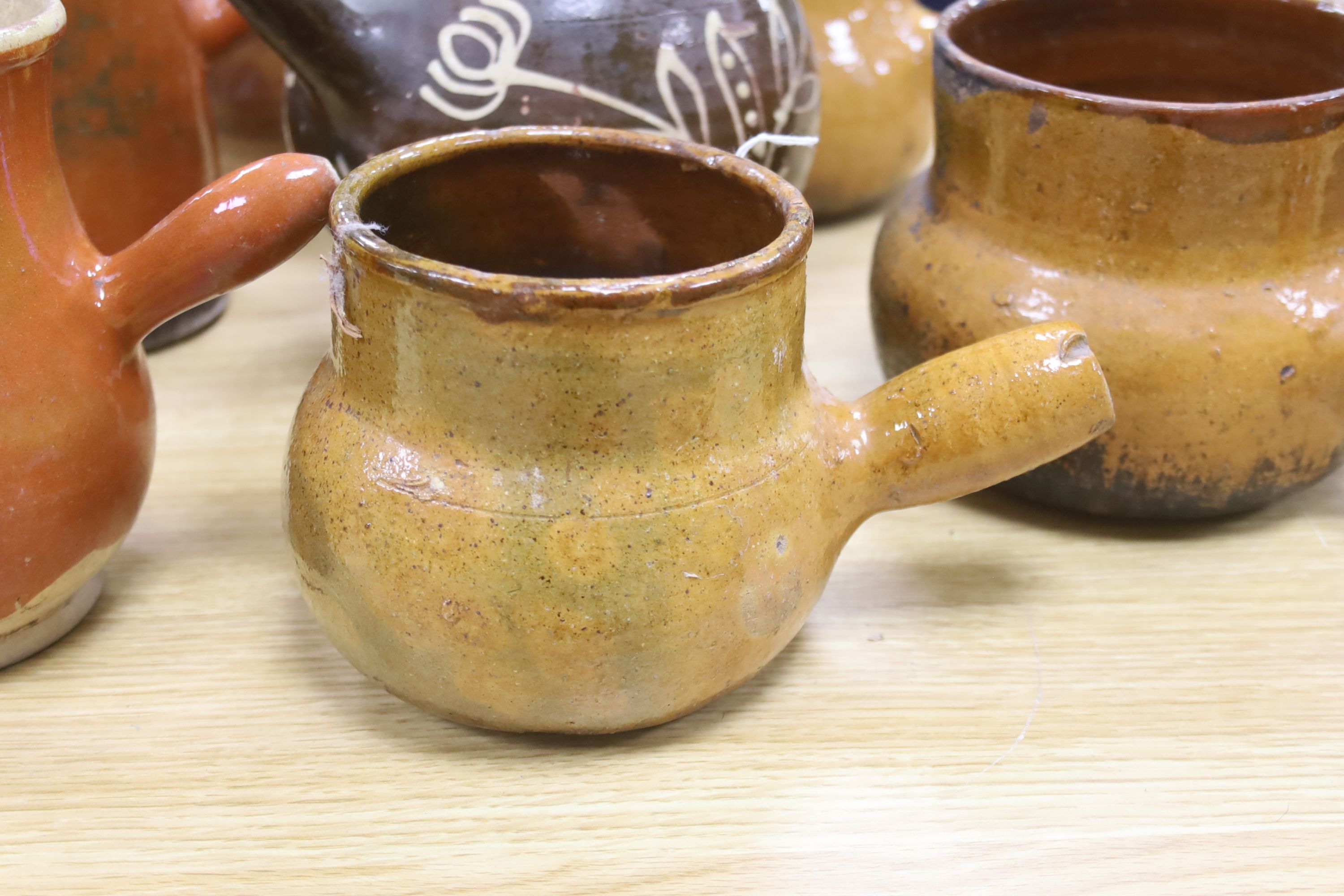 Six vintage Continental, probably French, glazed stoneware cooking pots and a slip-decorated stoneware confit pot